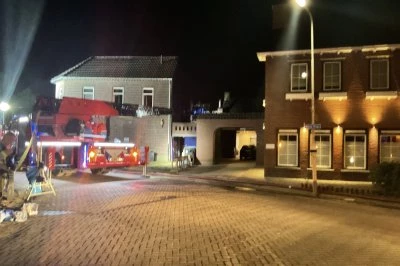 Brandweerauto's staan geparkeerd onder kunstlicht in een donkere straat.