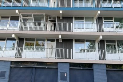 Drie verdiepingen van een modern appartementencomplex met balkons en een blauwe bovenkant.