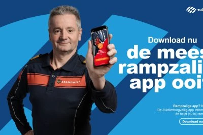 Man in uniform houdt smartphone vast met een app, gefotografeerd tegen een blauwe achtergrond.