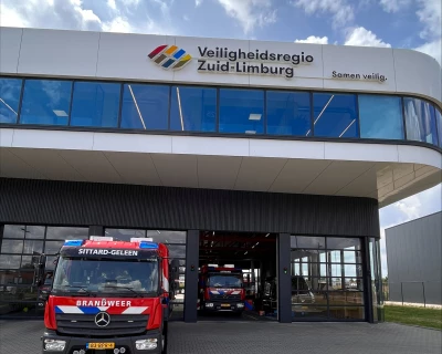 Een brandweerauto voor een gebouw met het logo van Veiligheidsregio Zuid Limburg.