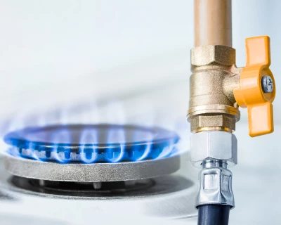 Brandende gaspit met blauwe vlam en afsluitkraan.